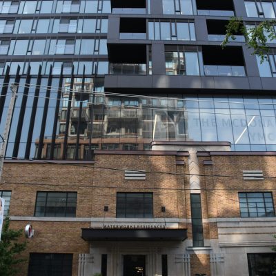 Exterior of a building with brick on the bottom and modern glass on top