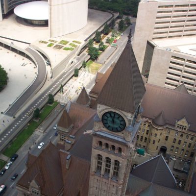 Birds eye view of an older looking brown building with a clock tower